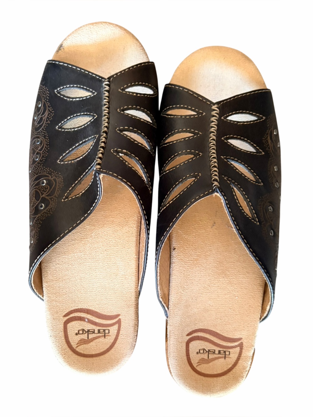 Black leather Dansko Sheri sandals featuring‎ geometric cutouts & studded detail